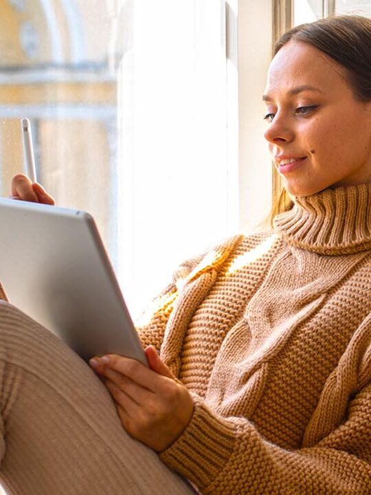 Moça lendo um livro na varanda.