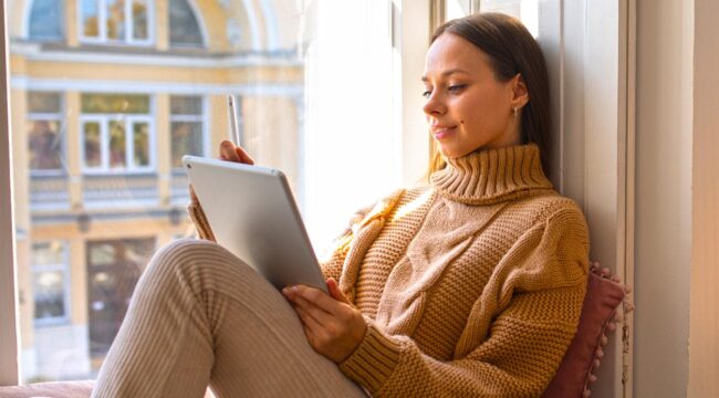 Moça lendo um livro na varanda.