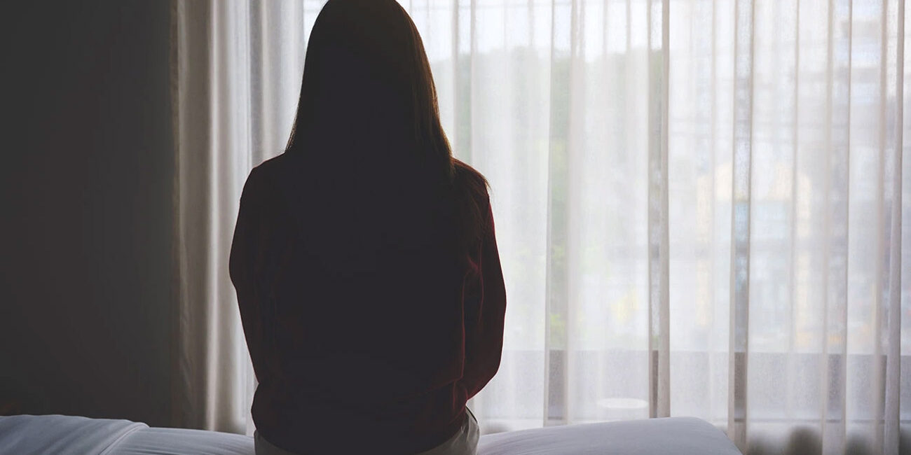 Mulher sozinha no quarto, com fobia social.