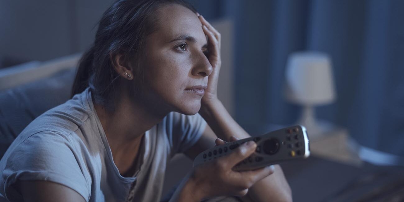 Mulher triste pelas notícias da TV.