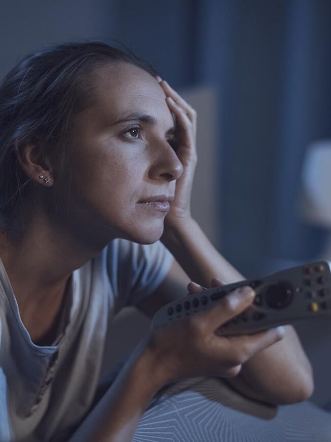 Mulher triste pelas notícias da TV.